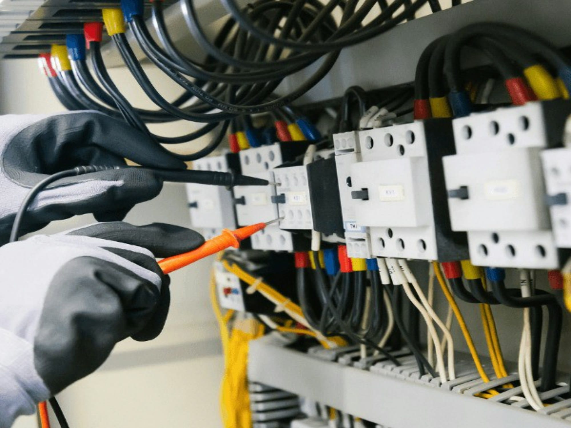 Elektriker efterser en el-tavle med måleinstrument